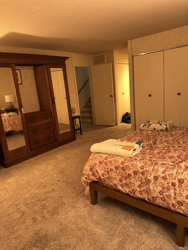 bedroom featuring a textured ceiling and light carpet