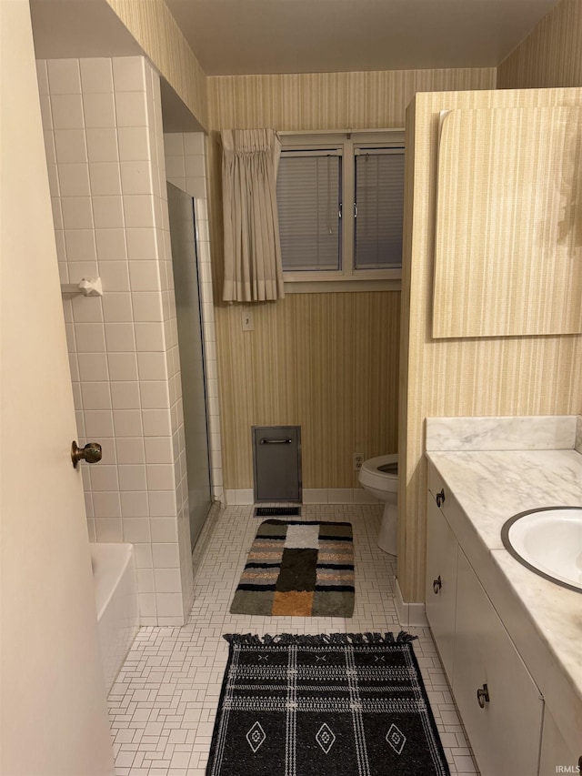 bathroom with a washtub, vanity, tile patterned floors, and toilet