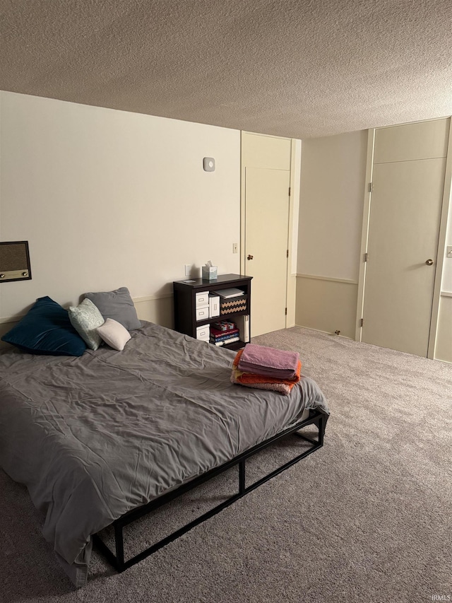 bedroom featuring carpet and a textured ceiling