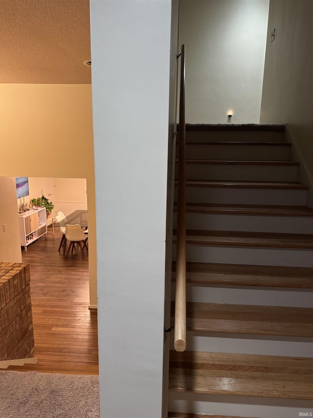 stairway featuring a textured ceiling