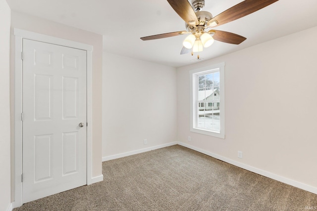 carpeted spare room with ceiling fan