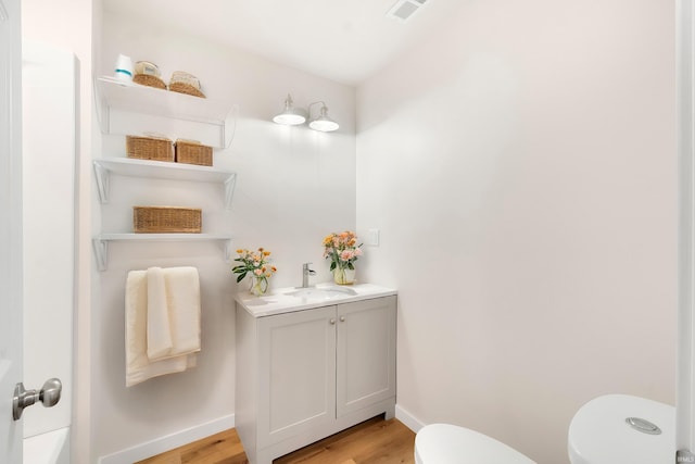 bathroom with vanity, hardwood / wood-style floors, and toilet