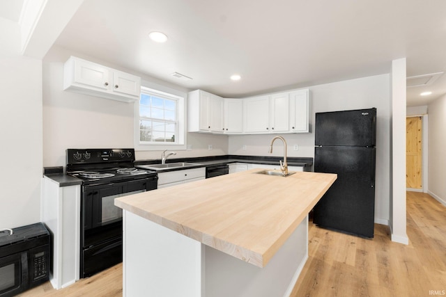 kitchen featuring sink, black appliances, white cabinets, and a kitchen island