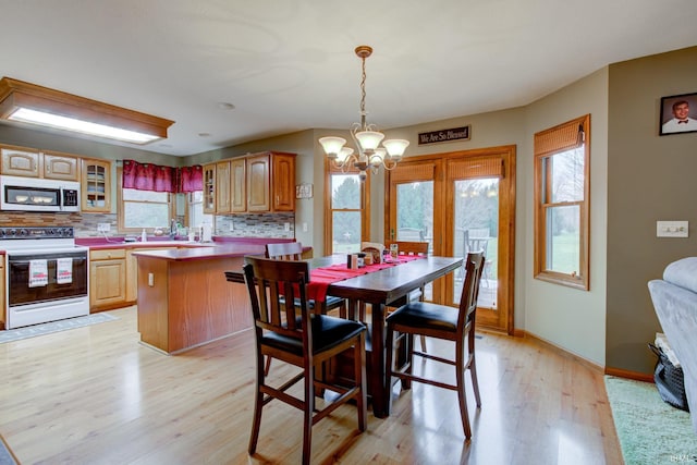 dining area featuring light hardwood / wood-style floors and an inviting chandelier