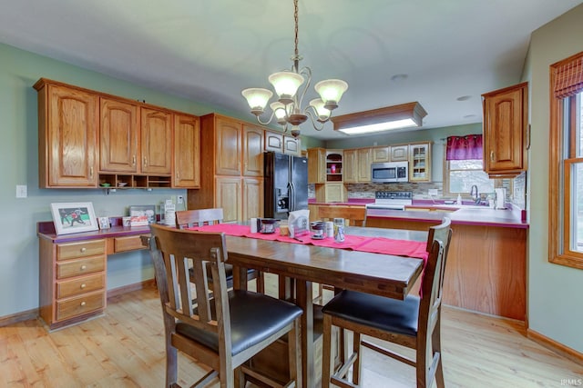 dining space featuring a notable chandelier, light hardwood / wood-style floors, and sink