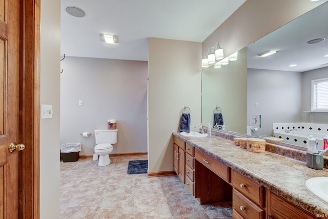 bathroom featuring vanity, toilet, and a washtub