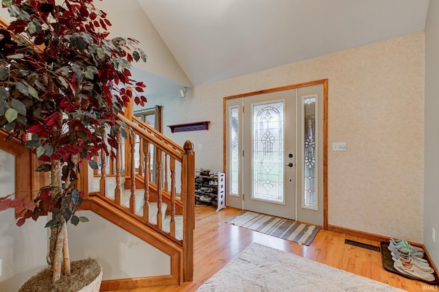 foyer featuring wood-type flooring and lofted ceiling