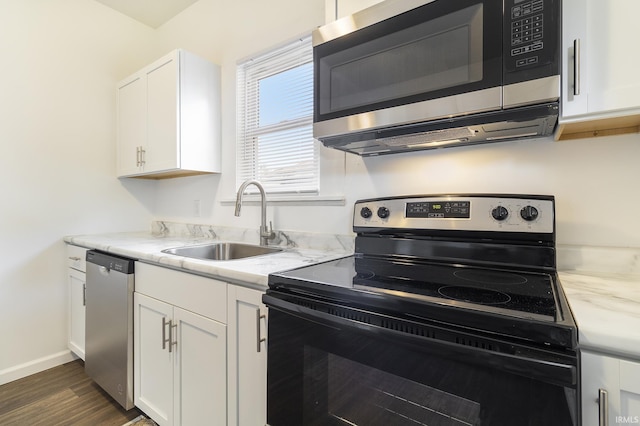 kitchen featuring electric range, sink, stainless steel dishwasher, dark hardwood / wood-style floors, and white cabinets