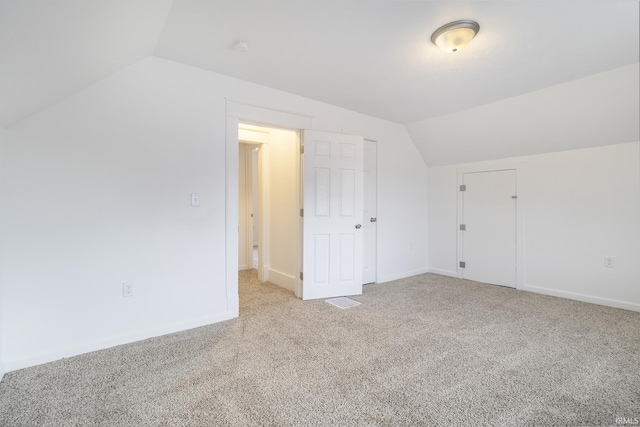 additional living space featuring light carpet and lofted ceiling