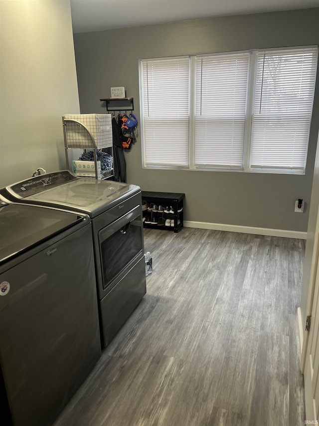 laundry area with cabinets, wood-type flooring, and washing machine and clothes dryer