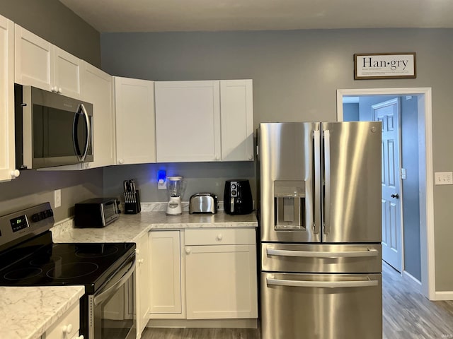 kitchen featuring white cabinetry, stainless steel appliances, and light hardwood / wood-style flooring