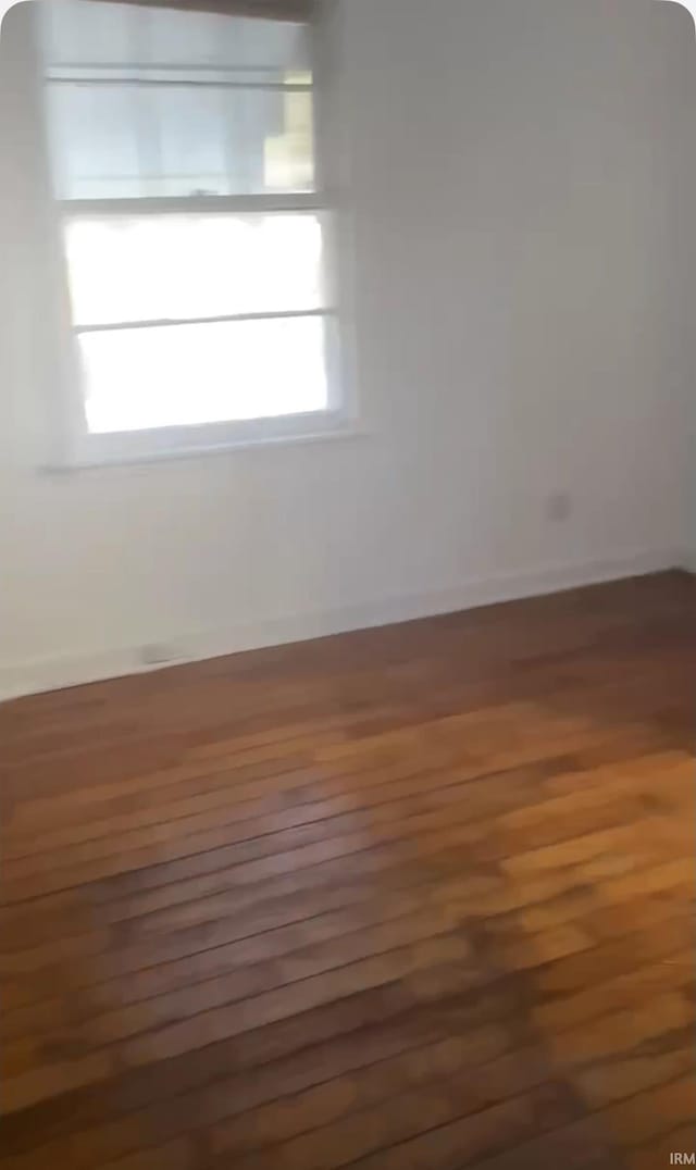 unfurnished room with dark wood-type flooring