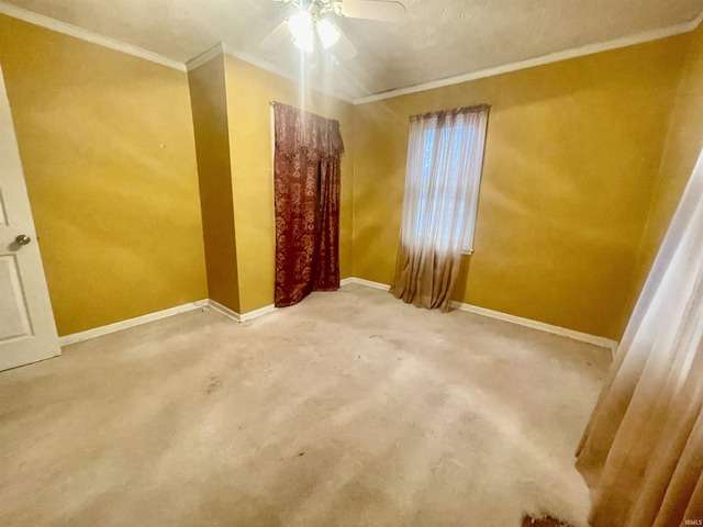 carpeted spare room with ceiling fan and crown molding