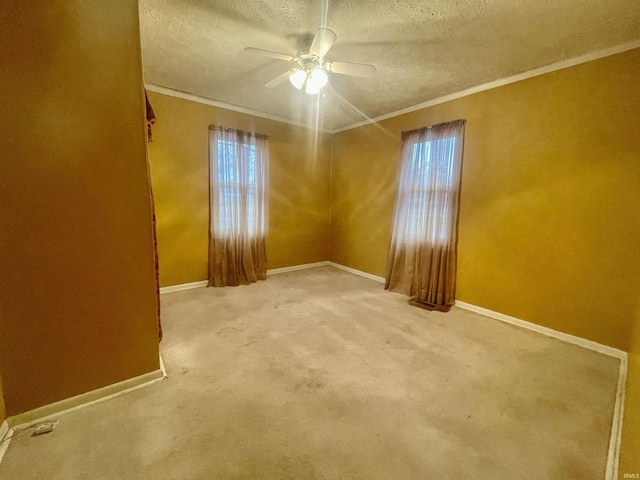 carpeted empty room with ceiling fan, a healthy amount of sunlight, crown molding, and a textured ceiling