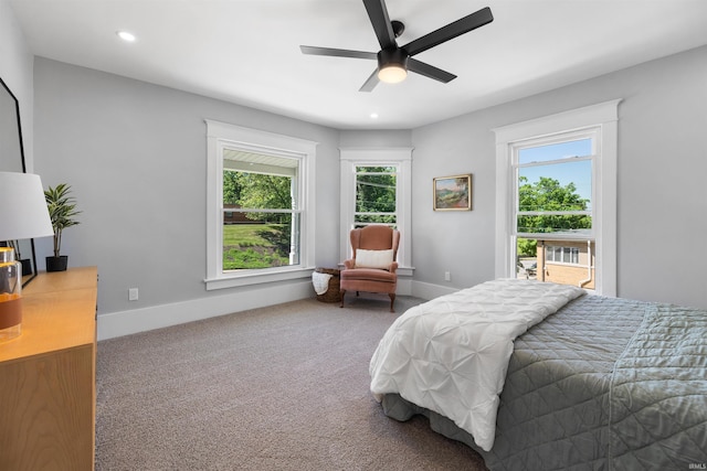 carpeted bedroom featuring multiple windows and ceiling fan