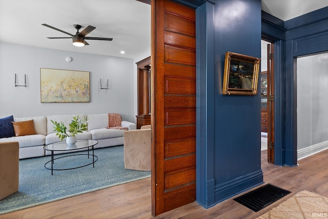 living room featuring ceiling fan and wood-type flooring