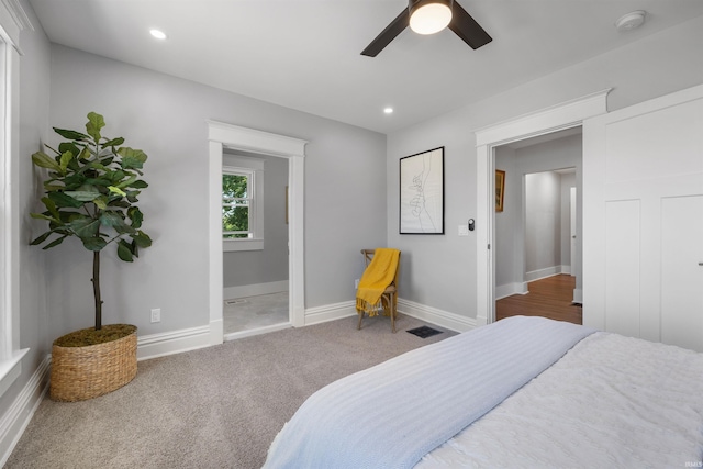 carpeted bedroom featuring ceiling fan and ensuite bathroom