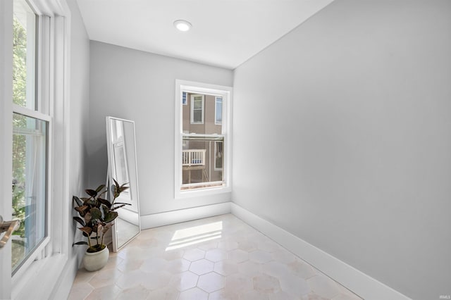 spare room with light tile patterned floors and a wealth of natural light