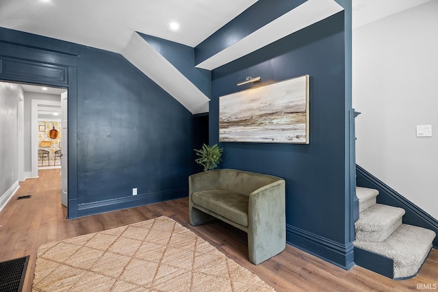 living area with hardwood / wood-style floors and lofted ceiling