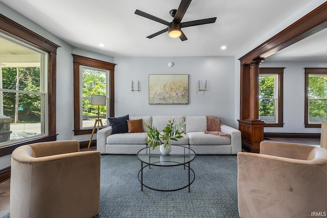 living room with ceiling fan and ornate columns