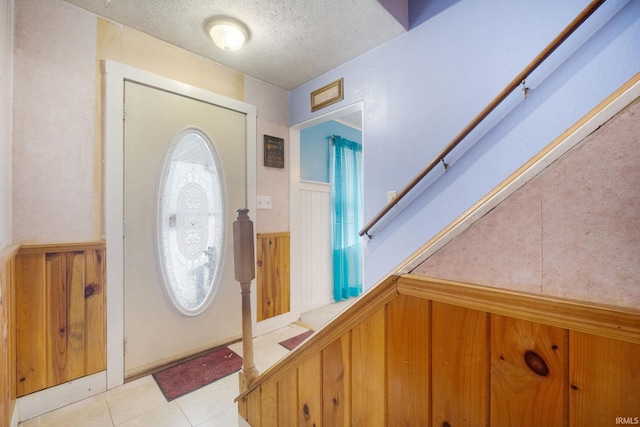 entrance foyer with a textured ceiling and light tile patterned flooring