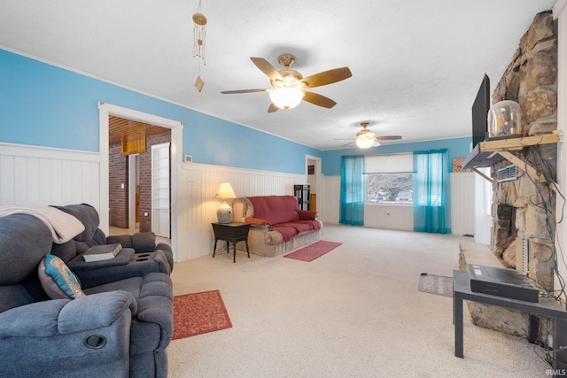 carpeted living room featuring ceiling fan and a textured ceiling