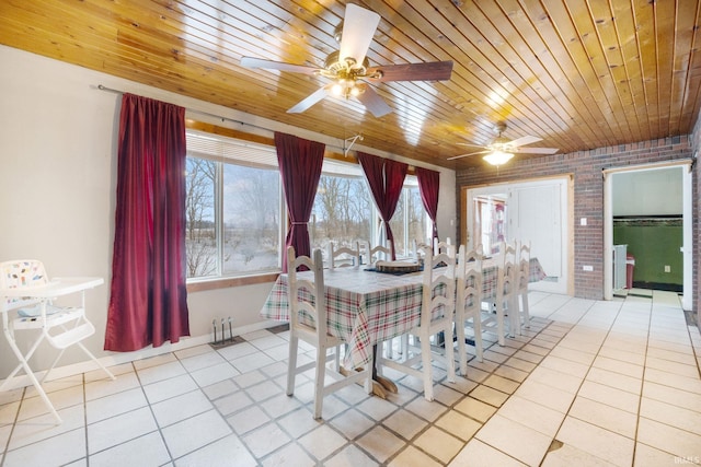 dining area with ceiling fan, light tile patterned floors, wood ceiling, and brick wall