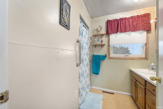 bathroom featuring tile patterned floors, vanity, and a textured ceiling