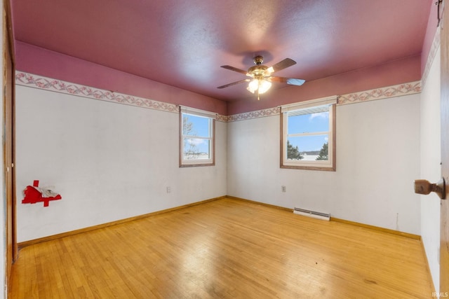 unfurnished room featuring a baseboard radiator, light hardwood / wood-style flooring, plenty of natural light, and ceiling fan