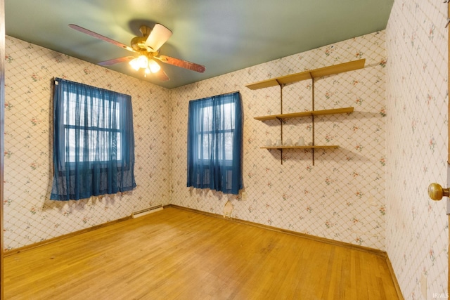 spare room featuring a wealth of natural light, ceiling fan, and wood-type flooring