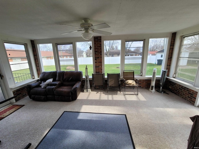 sunroom / solarium featuring ceiling fan and a water view