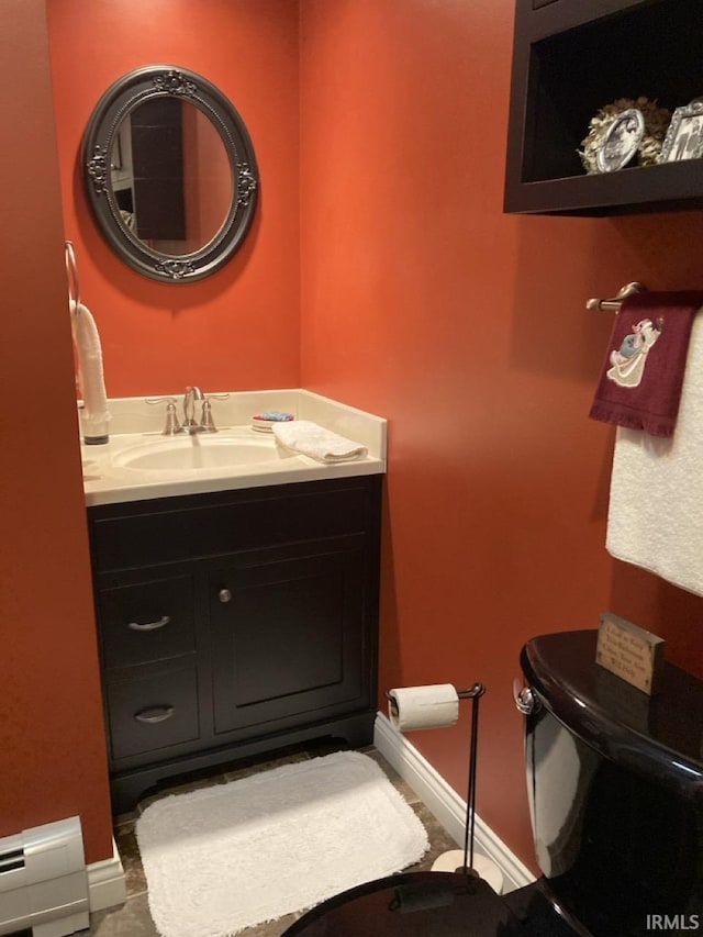 bathroom with vanity, toilet, and a baseboard heating unit