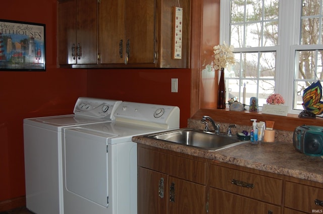 clothes washing area featuring cabinets, separate washer and dryer, and sink