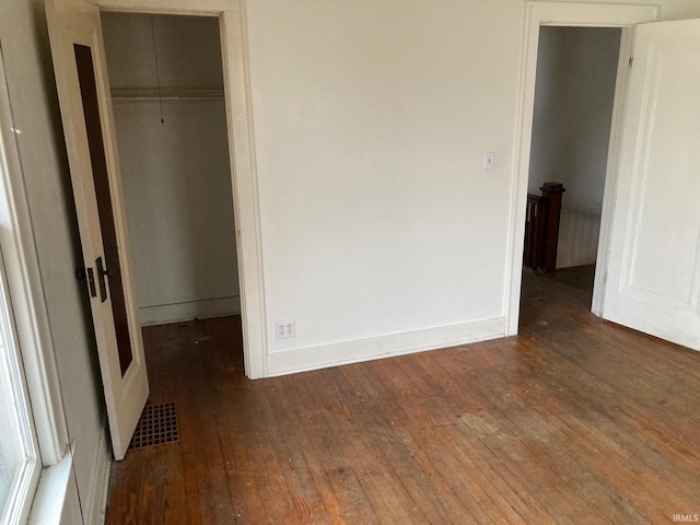 unfurnished bedroom with dark hardwood / wood-style floors and a closet