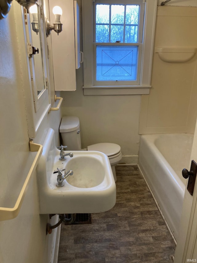 bathroom with hardwood / wood-style flooring, toilet, and sink