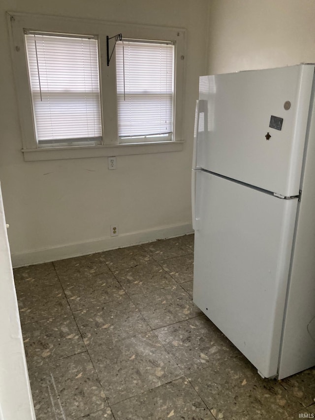 kitchen featuring white fridge and a wealth of natural light