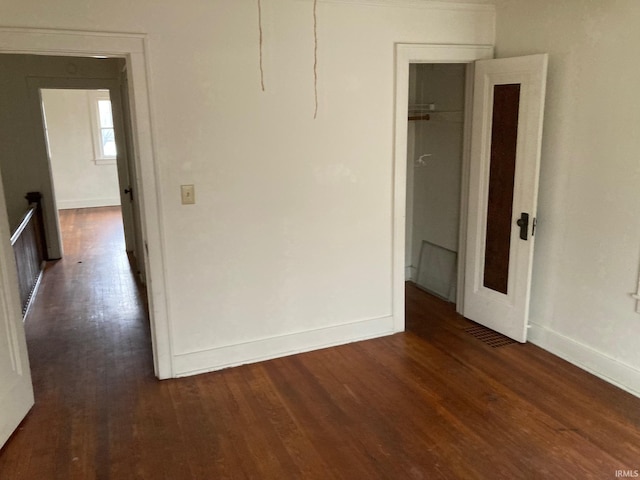 empty room with dark hardwood / wood-style flooring