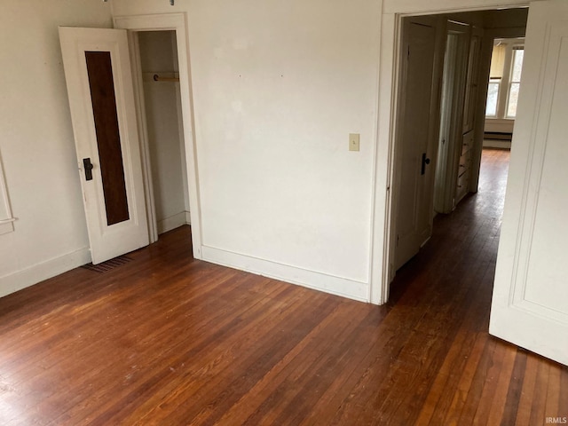 spare room featuring dark hardwood / wood-style floors and a baseboard heating unit