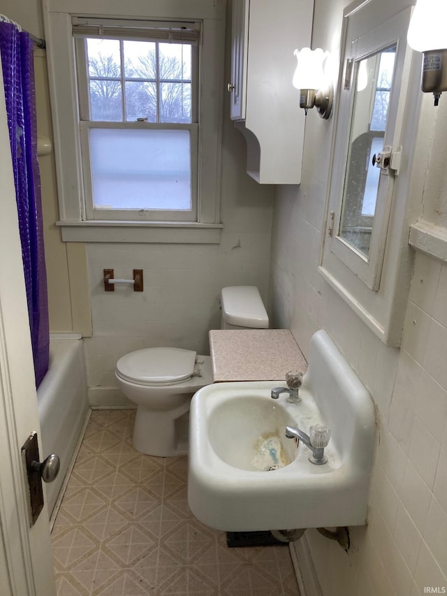 full bathroom with toilet, shower / bath combo with shower curtain, and sink