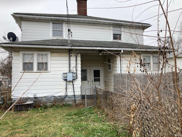 rear view of property with a lawn