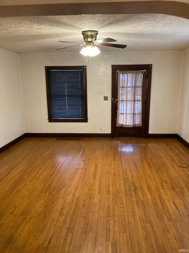 empty room with hardwood / wood-style floors and a textured ceiling