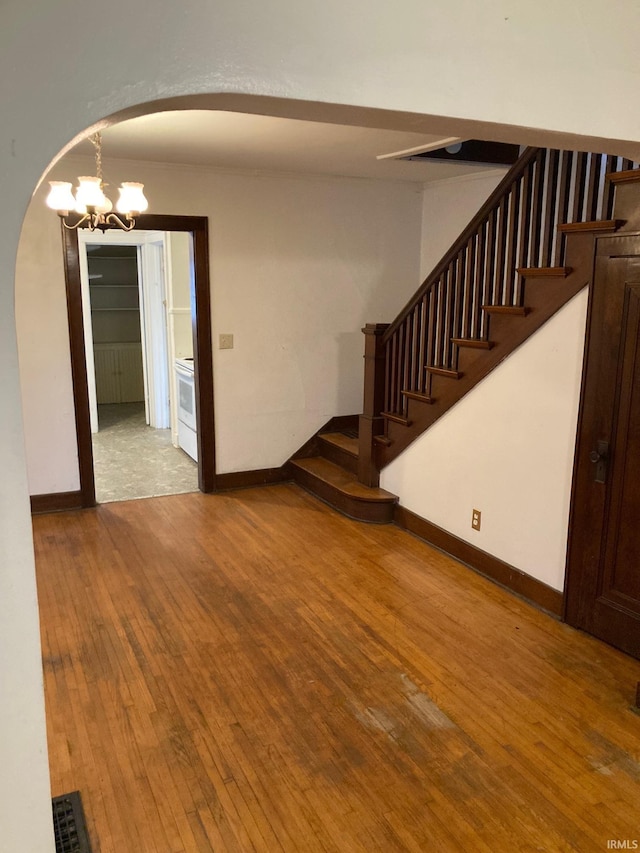 unfurnished room featuring a chandelier and hardwood / wood-style floors