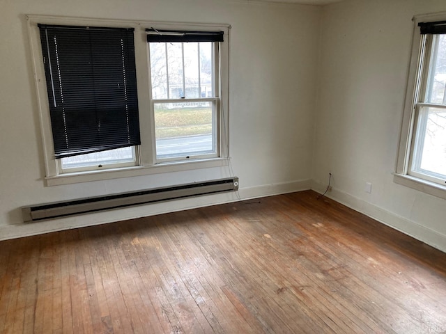 spare room with a baseboard radiator and wood-type flooring