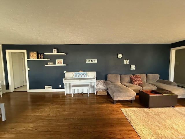 living room with wood-type flooring and a textured ceiling