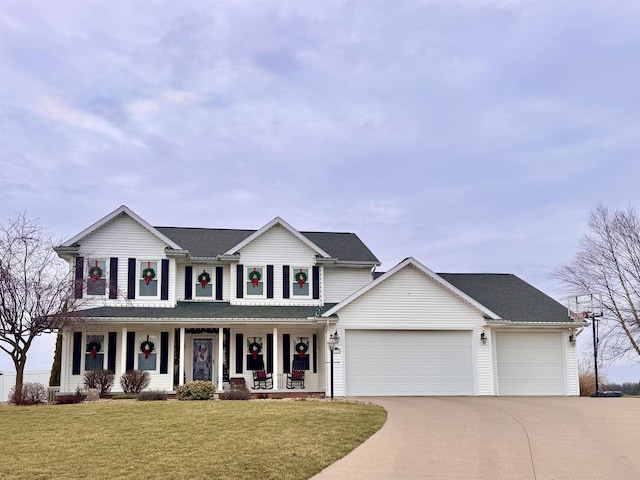 view of front of home with covered porch, a garage, and a front yard