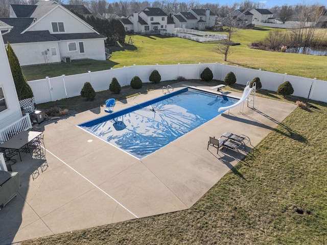 view of swimming pool with a diving board, a yard, a water slide, and a patio