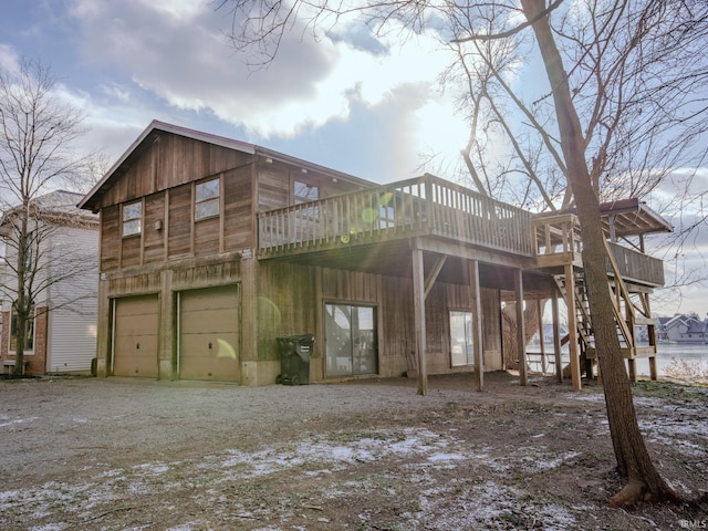 back of house with a garage and a deck