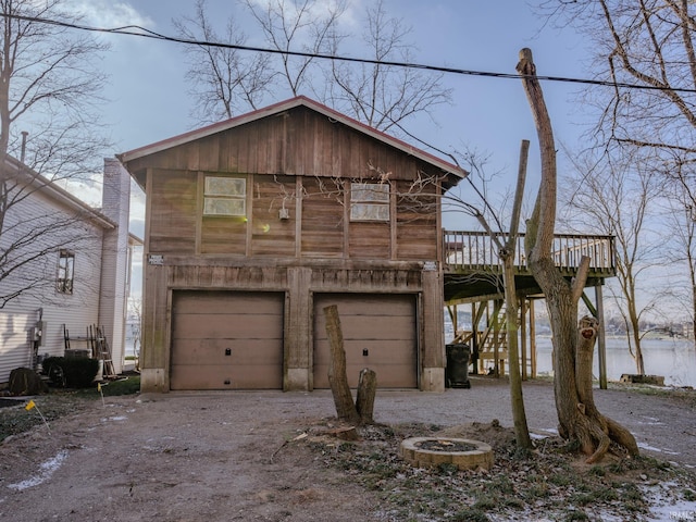 view of front of property featuring a deck with water view and a garage