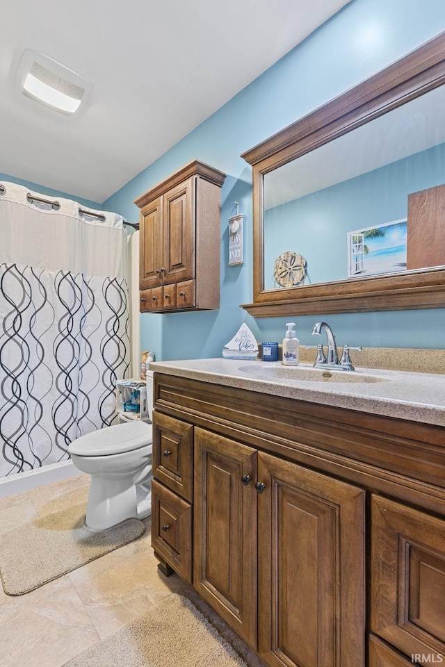 bathroom featuring vanity, toilet, and curtained shower