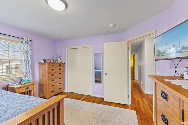 bedroom with light hardwood / wood-style flooring and a closet